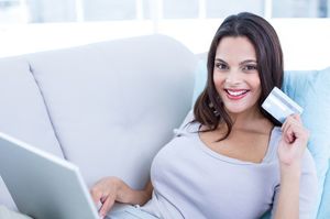 パソコンをしながらカードを持つ女性