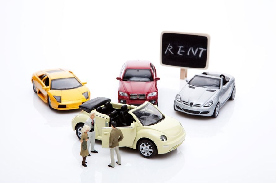 車と人の模型と「RENT」と書かれた看板