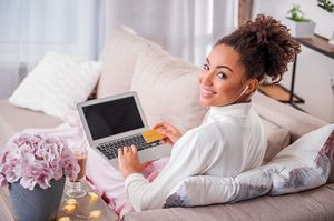 ゴールドカードを持ちながらパソコンをする女性