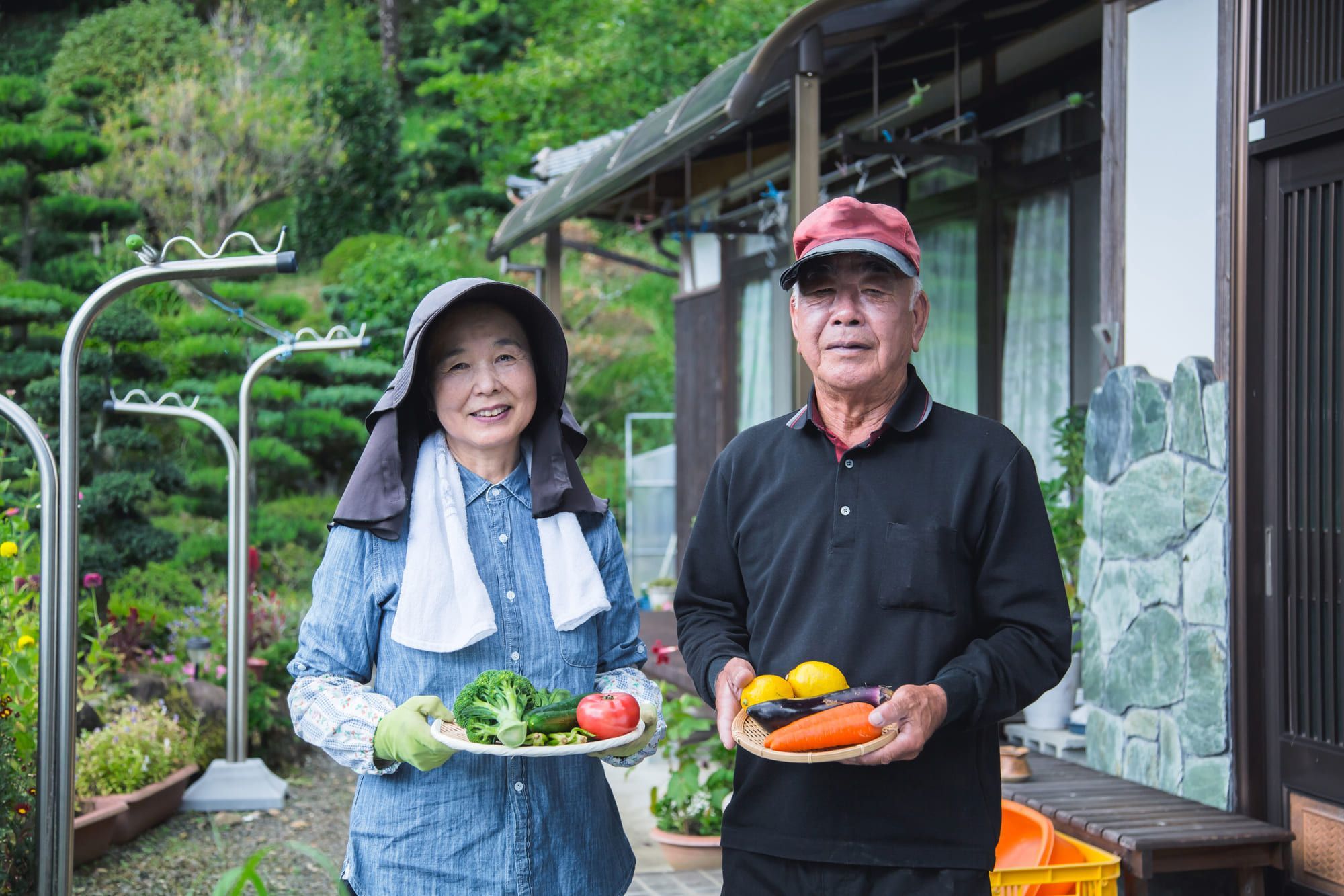 おじいさんとおばあさんが野菜かごを持っている