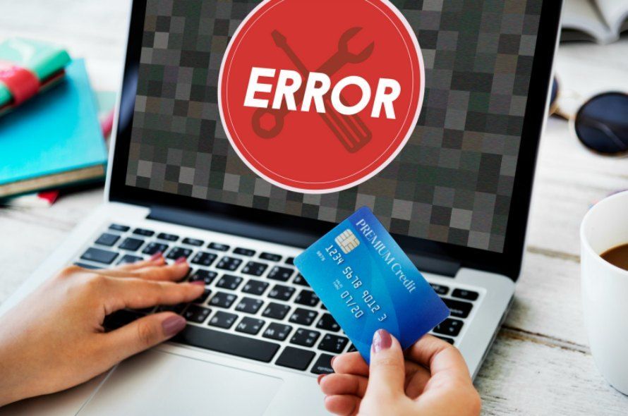 ERRORが表示されているパソコンとクレジットカードを持っている人